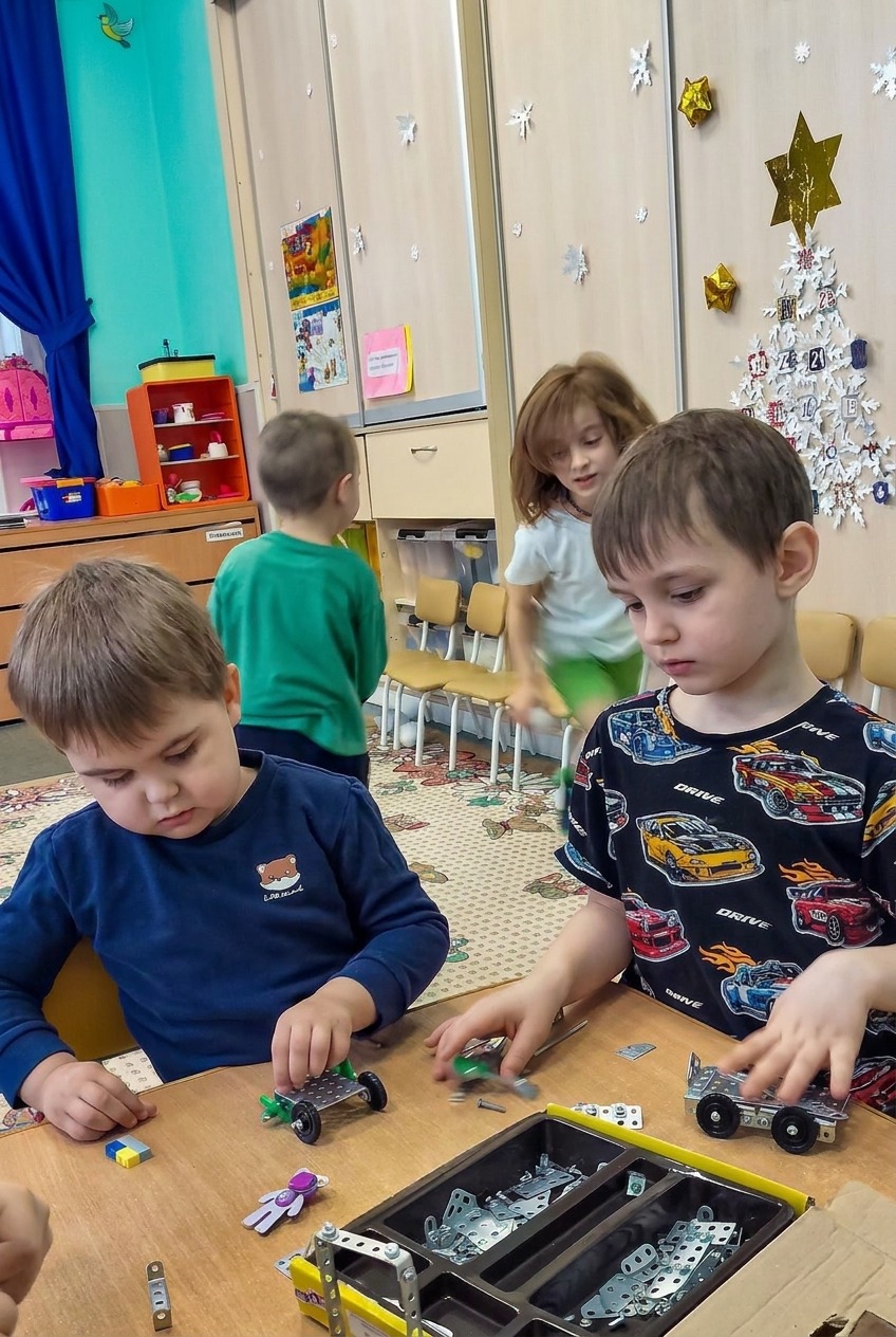 Дети вместе собирают модели из конструктора